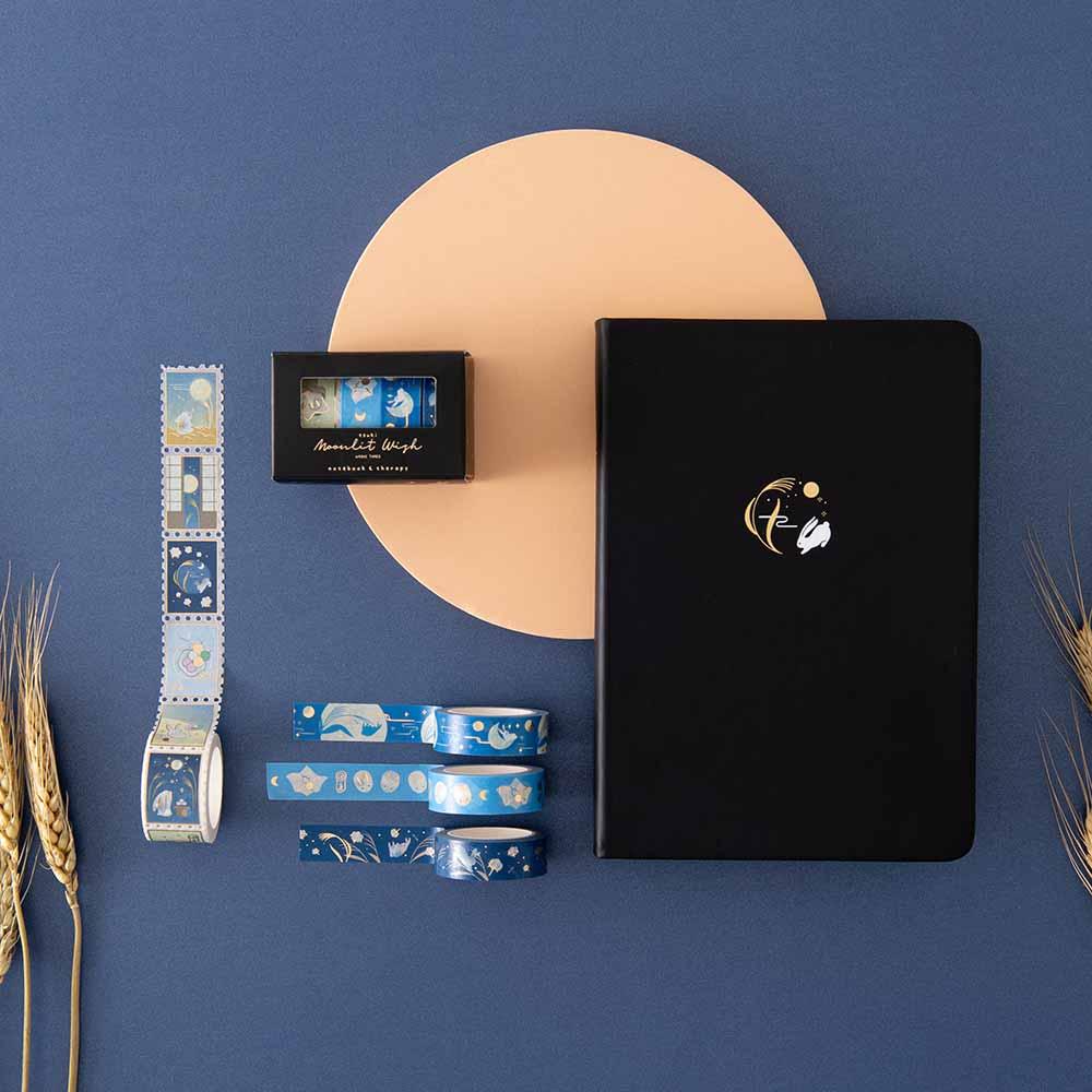 Tsuki ‘Moonlit Wish’ Limited Edition Bullet Journal with Tsuki ‘Moonlit Wish’ Washi Tapes Set on brown circle with wheat reeds on dark blue background