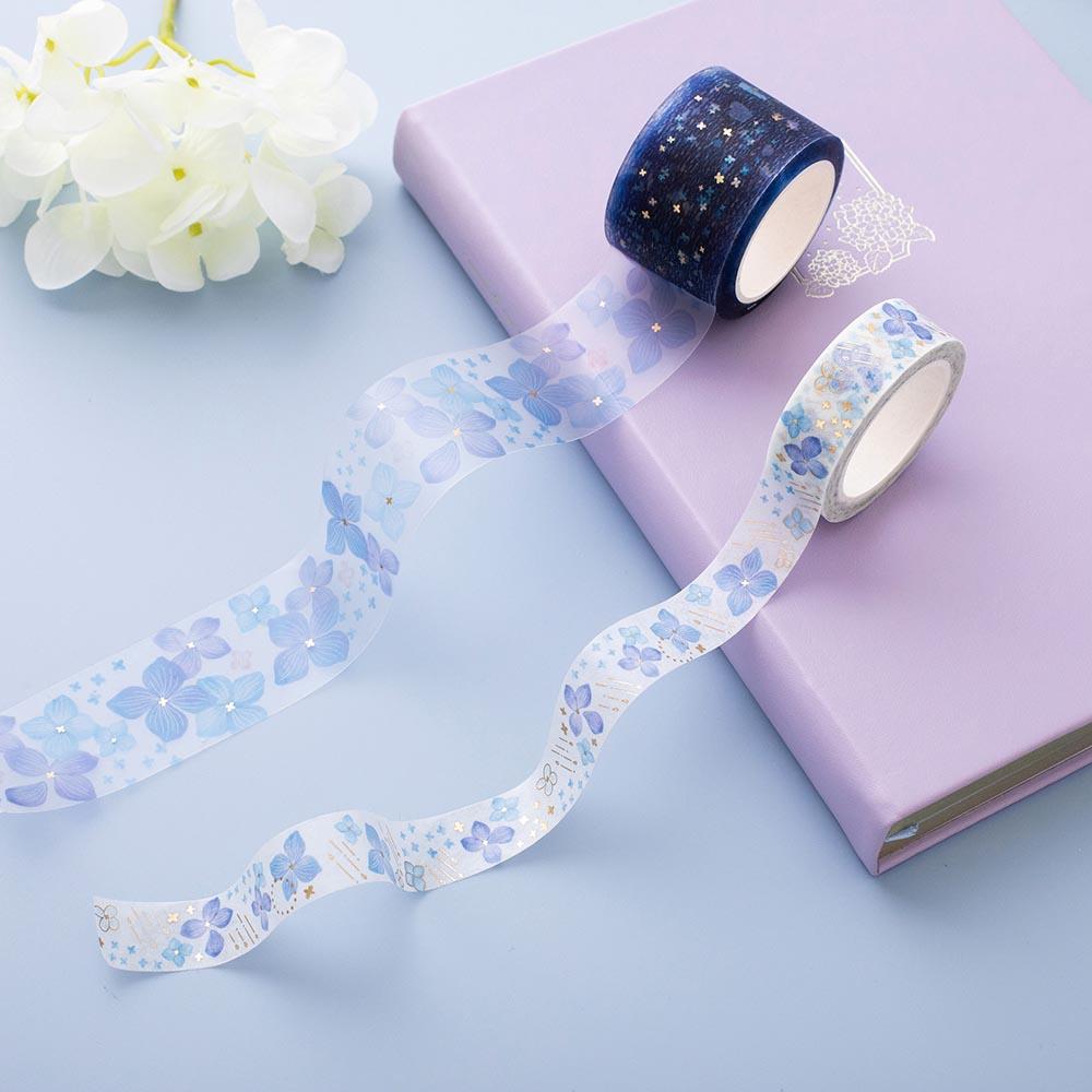 Close up of Tsuki Endless Summer Washi Tape Set with Tsuki Endless Summer Limited Edition Bullet Journal in Lilac Bloom and white hydrangea flowers on light blue background