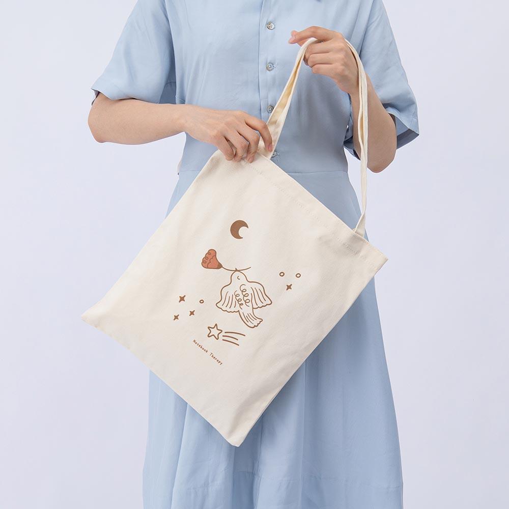 Tsuki ‘Moonflower’ Limited Edition Tote Bag held in hands by model on light blue background