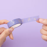 Tsuki Floral Lilac Taro Washi tape rolled out in hands in lilac background