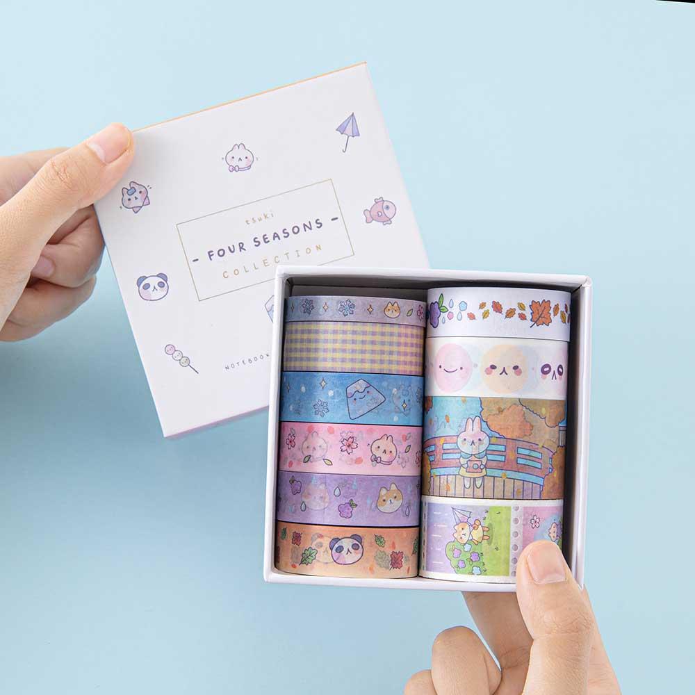 Tsuki ‘Four Seasons’ Washi Tape Set by Notebook Therapy x Milkkoyo held in hands in light blue background