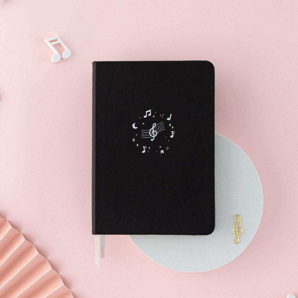 Tsuki Lunar Notes bullet journal with music notes flat lay image on pink background
