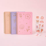 Tsuki floral ringbound notebooks in sakura pink, lilac taro and honey peach with free sticker sheet on pink background