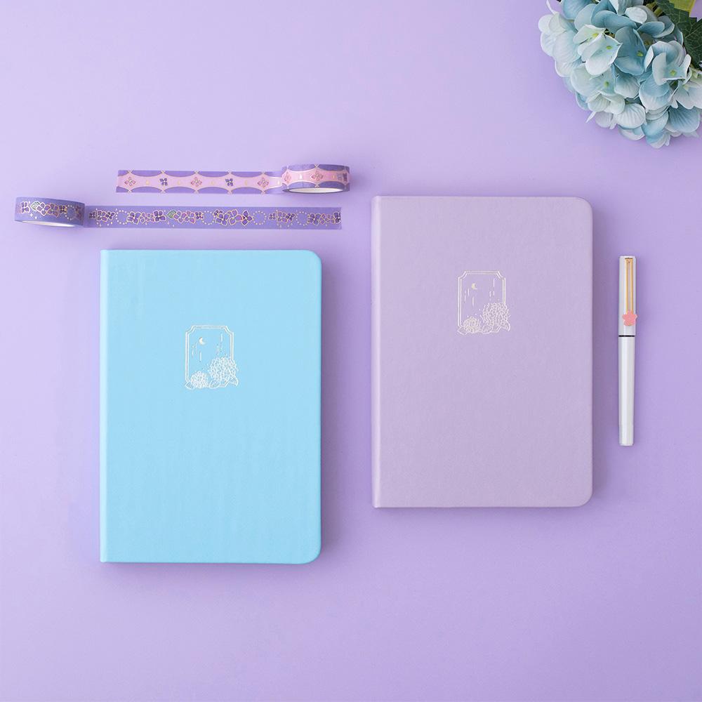 Tsuki Endless Summer Limited Edition Bullet Journals in Lilac Bloom and Petal Blue with Tsuki Endless Summer washi tape rolls with pen and light blue hydrangea flowers on lilac background