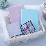 Tsuki Endless Summer Limited Edition Bullet Journals in Lilac Bloom and Petal Blue with Tsuki Endless Summer Washi Tape Set in basket with netting on light blue background