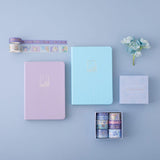 Tsuki Endless Summer Limited Edition Bullet Journals in Lilac Bloom and Petal Blue with Tsuki Endless Summer Washi Tape Set with light blue hydrangea flowers on light blue background