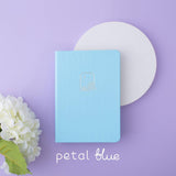 Tsuki Endless Summer Limited Edition Bullet Journal in Petal Blue with white circle and white hydrangea flowers on lilac background