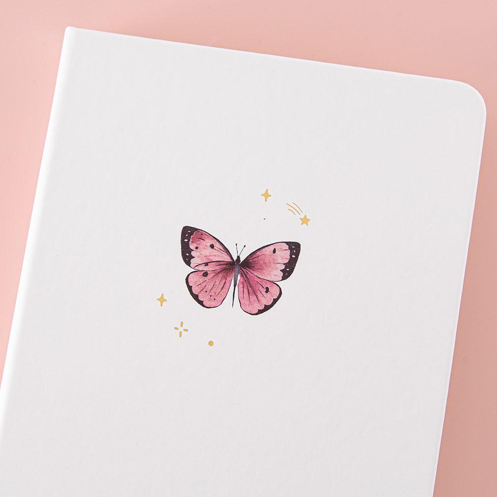 Close up of the front cover of Tsuki Cloud White ‘Flutter + Dream’ Limited Edition Bullet Journal by Notebook Therapy x Pelinkan on pastel pink background