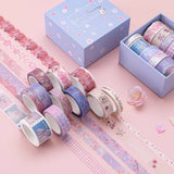 Close up of Tsuki ‘Sakura Journey’ Washi Tape Set rolled out with cherry blossoms on light pink background