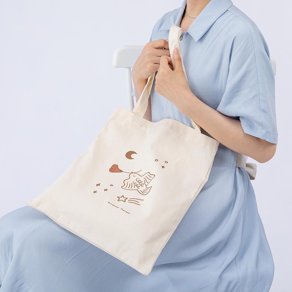Tsuki ‘Moonflower’ Limited Edition Tote Bag shown on model’s knee on light blue background