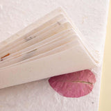 Close up of the corners of Tsuki Handmade Petal Paper Pack on cream background