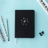 Tsuki Lunar Notes bullet journal with stationary flat lay image on blue background