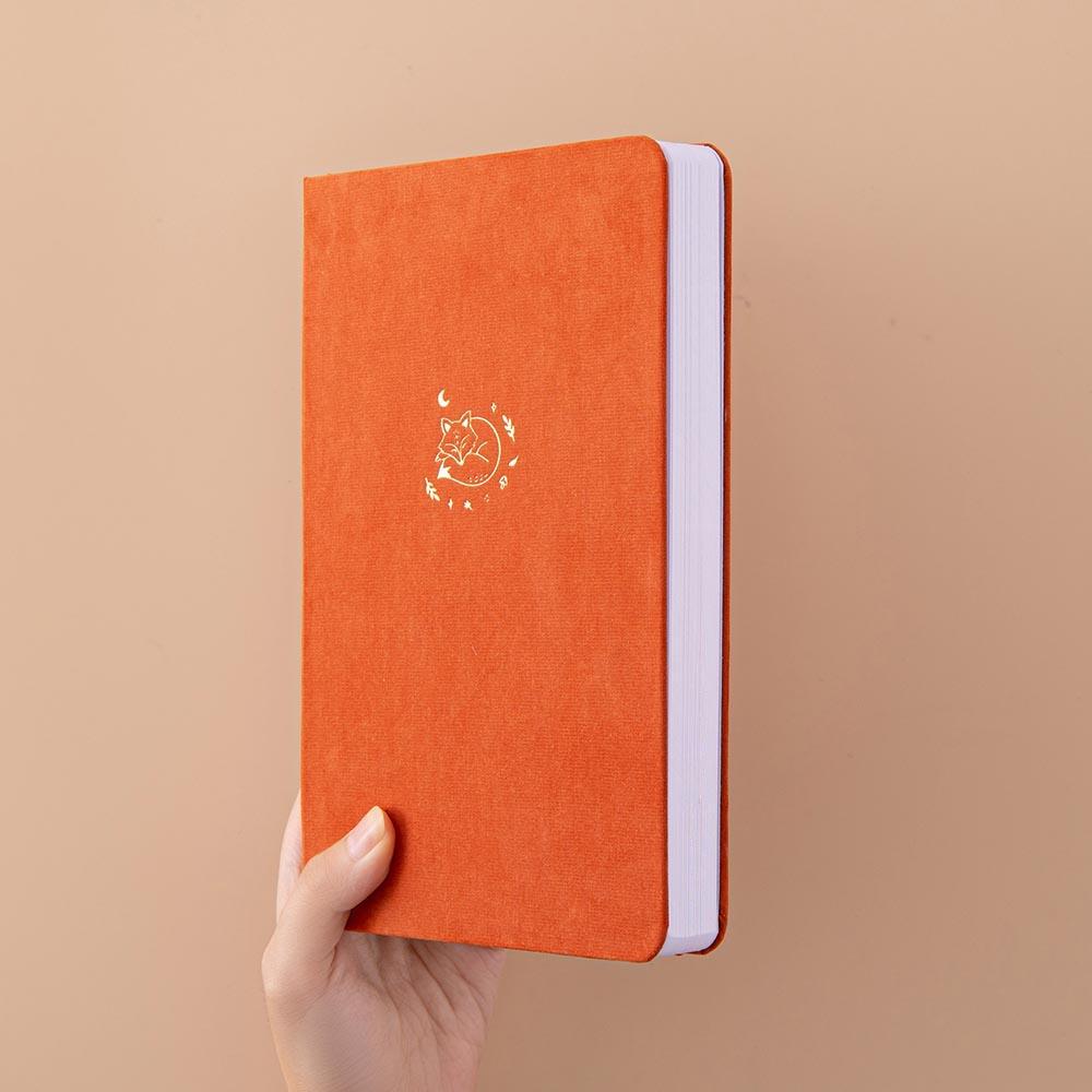 Tsuki ‘Kitsune’ Limited Edition Fox Bullet Journal held in hand at spine angle in beige background