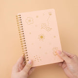 Tsuki honey peach floral ringbound notebook held in hands in peach background