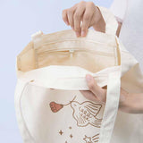 Close up of inside zipped pocket of Tsuki ‘Moonflower’ Limited Edition Tote Bag held in hands on light blue background