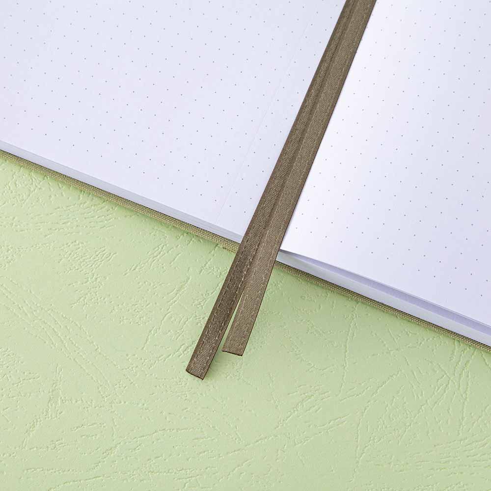 Close up of open pages and two bookmark ribbons of Tsuki ‘Matcha Matcha’ Limited Edition Bullet Journal on matcha green background