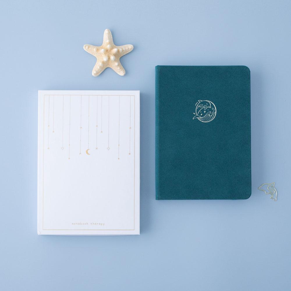 Tsuki sea green velvet Dolphin Days notebook with eco-friendly box packaging and starfish on blue background