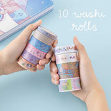Tsuki ‘Four Seasons’ Washi Tape Set by Notebook Therapy x Milkkoyo held in hands with Tsuki ‘Four Seasons: Winter Edition’ Bullet Journal on light blue background