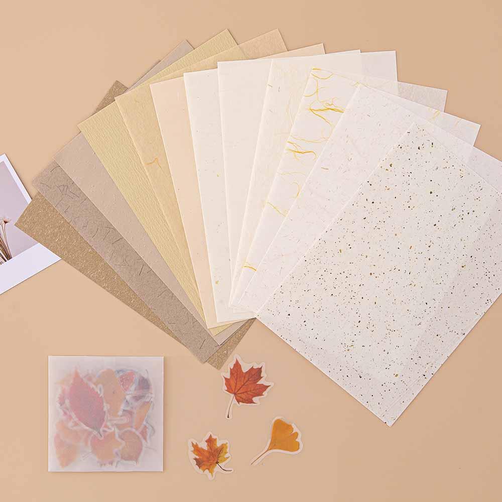 Tsuki Mixed Scrapbook Paper Pack fanned out with free stickers with polaroid picture on beige background