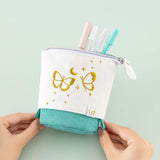 Tsuki ‘Flutter + Dream’ Pop-Up Pencil Case by Notebook Therapy x Pelinkan in teal held in hands in mint background