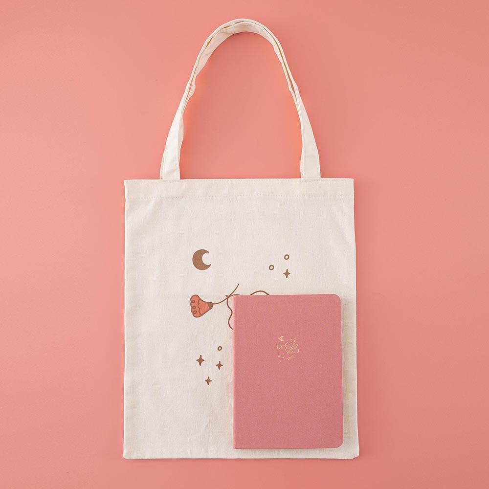 Tsuki ‘Moonflower’ Limited Edition Tote Bag with ‘Suzume’ Limited Edition Bullet Journal on coral pink background