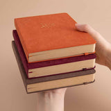 Tsuki Kraft Paper Limited Edition Bullet Journal in Kitsune and Nara and Kinoko stacked and held in hands in beige background