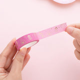 Tsuki Floral sakura pink Washi tape rolled out in hands in pink background