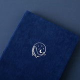Close up of the front cover of deep blue textured vegan leather Tsuki Gentle Giant luxury edition bullet journal on deep blue background