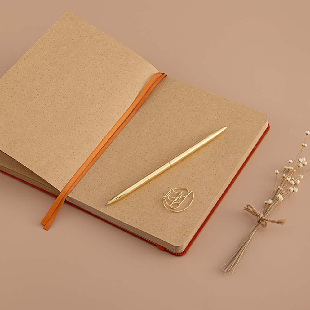 Open Tsuki Kraft Paper Limited Edition Bullet Journal in Kitsune with free bookmark gift with gold pen and dried flowers on beige background