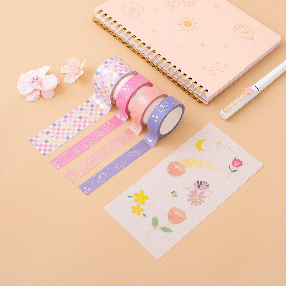 Tsuki Floral washi tapes rolled out with sticker sheet and honey peach ringbound bujo on peach surface