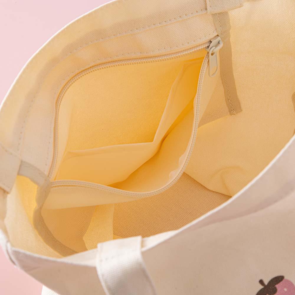 Close up of the inside of Tsuki ‘Ichigo’ Boba Tote Bag with inside zippable pocket on light pink background