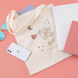 Tsuki ‘Moonflower’ Limited Edition Tote Bag with ‘Suzume’ Limited Edition Bullet Journal with laptop and sunglasses and phone on coral pink background