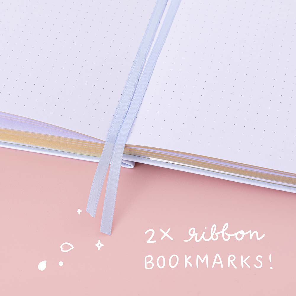 Close up of Tsuki ‘Sakura Journey’ Limited Edition Bullet Journal with two bookmark ribbons on pink background