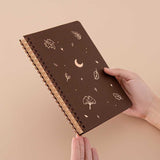 Tsuki ‘Maple Dreams’ Kraft Paper Ringbound Bullet Journal held in hands at an angle in beige background