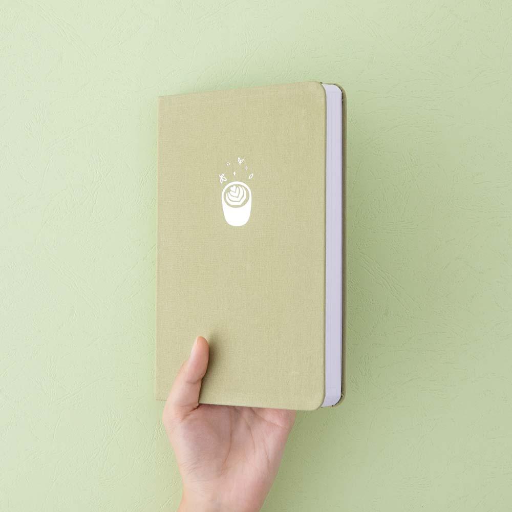Tsuki ‘Matcha Matcha’ Limited Edition Bullet Journal held in hand at spine angle in matcha green background