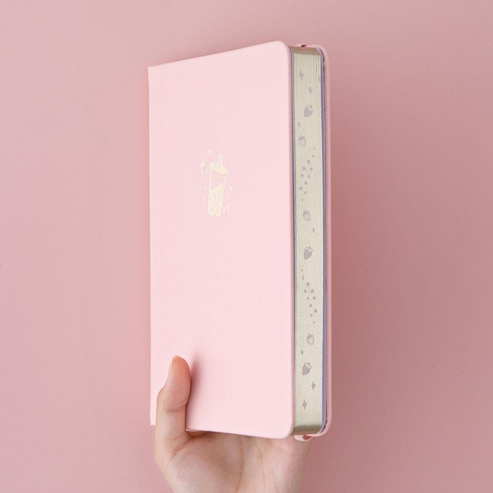 Tsuki ‘Ichigo’ Limited Edition Boba Bullet Journal held in hand at spine angle in light pink background