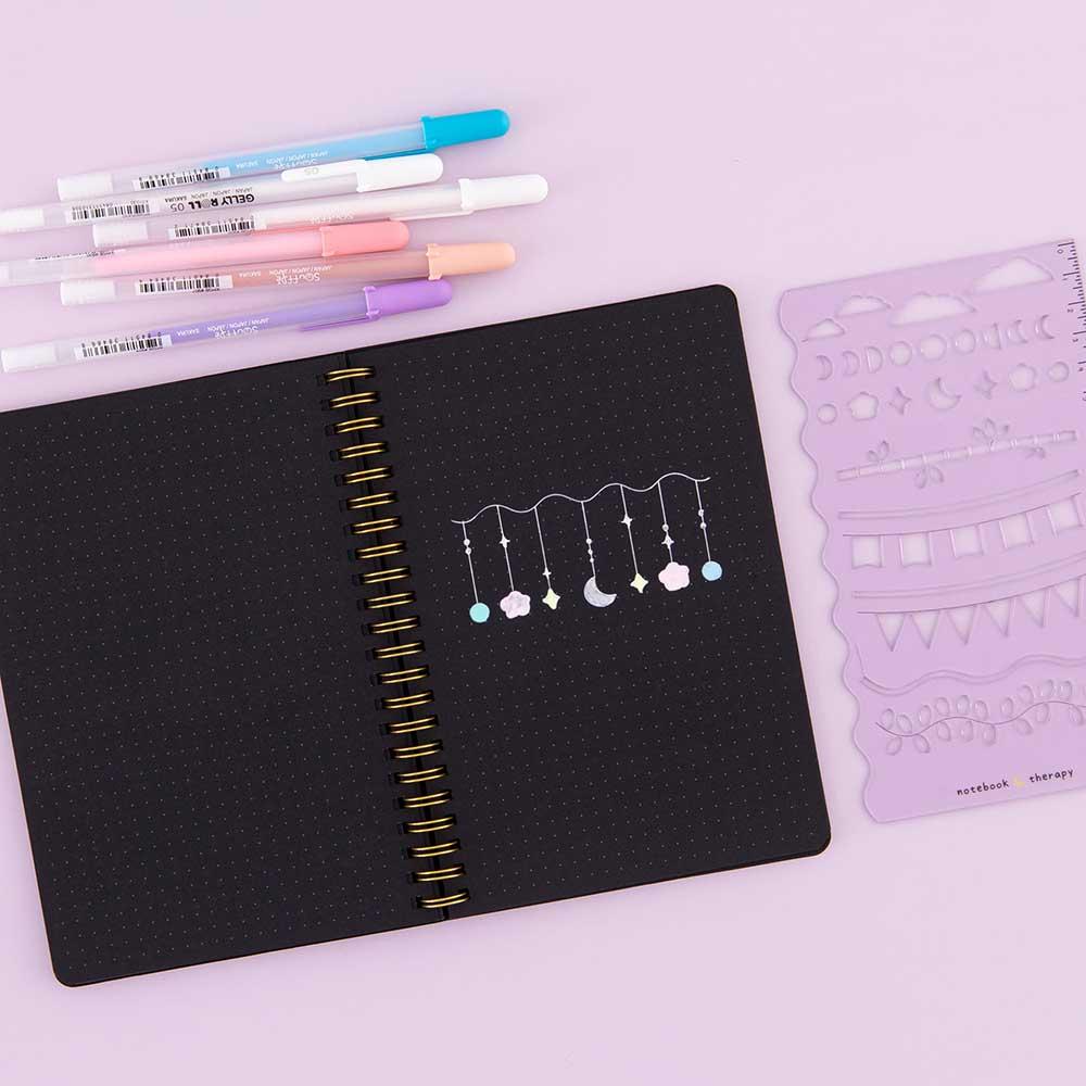 Open Tsuki Black Paper Ringbound Bullet Journal with Gelly Roll Pens and Tsuki Bullet Journal Stencil Set in Lilac Taro on lilac background