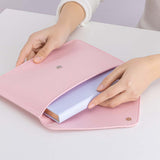 Tsuki ‘Sakura Journey’ Notebook Pouch held in hands with Tsuki ‘Sakura Journey’ Limited Edition Bullet Journal inside on white table