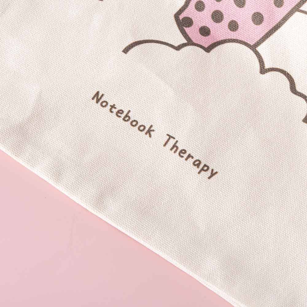 Close up of Tsuki ‘Ichigo’ Boba Tote Bag matcha design with Notebook Therapy logo on light pink background