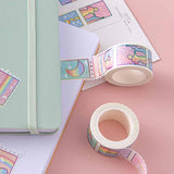 Close up of Tsuki Rainbow Pride Washi Tape on open notebook page with Tsuki Pastel Edition mint matcha bullet journal and postcard on light pink background