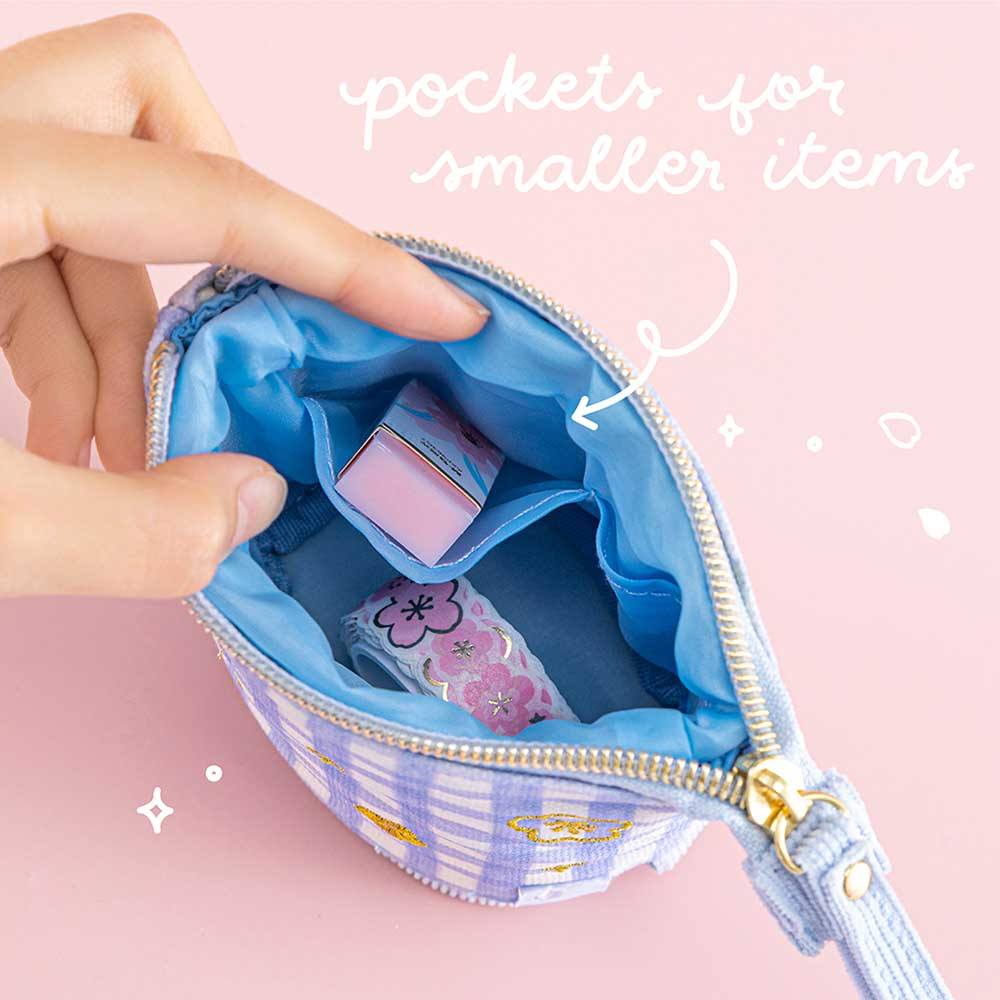 Close up of open Tsuki ‘Sakura Journey’ Pop-Up Pencil Case with pockets for smaller items held in hands with Tsuki ‘Sakura Journey’ Washi Tape and eraser inside in light pink background