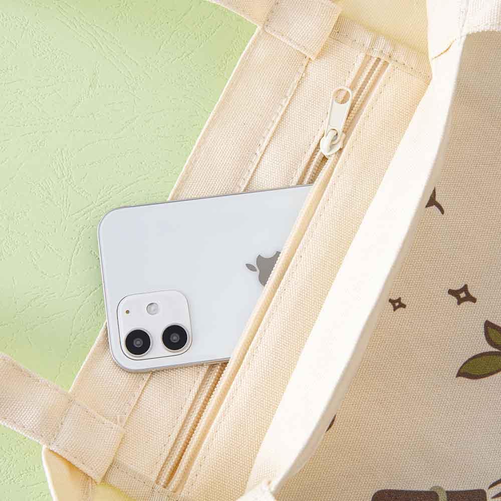 Close up of the zippable pocket of Tsuki ‘Matcha Matcha’ Tote Bag with mobile phone on matcha green background