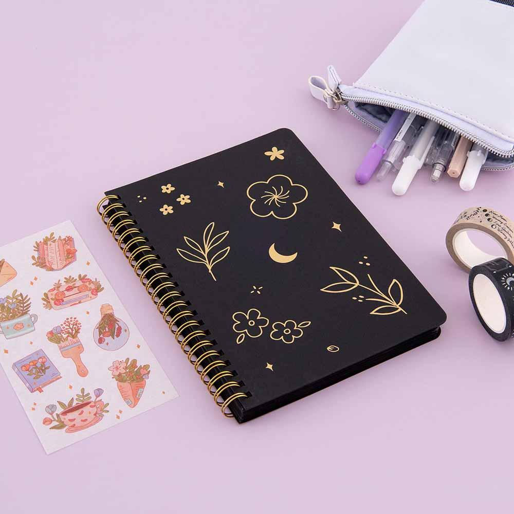 Tsuki Black Paper Ringbound Bullet Journal with free stickers sheet and Tsuki Moonlit Spells Washi Tapes and Tsuki Pop-Up Pencil Case on lilac background