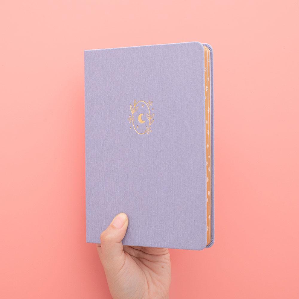 Tsuki ‘Full Bloom’ Limited Edition Bullet Journal held in hands in coral pink background