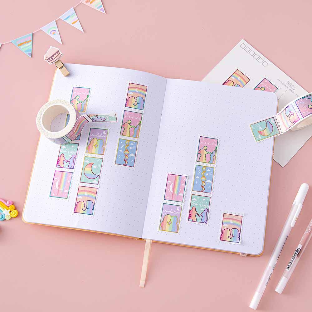 Tsuki Rainbow Pride Washi Tape on open Tsuki Pastel Edition bullet journal page with postcard and pens and bunting on light pink background