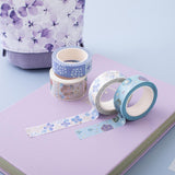 Close up of Tsuki Endless Summer Washi Tape Set with Tsuki Endless Summer Limited Edition Bullet Journal in Lilac Bloom and Tsuki Endless Summer pop up pencil case in Lilac Bloom on light blue background