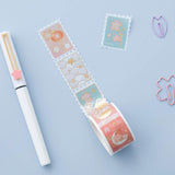 Tsuki 'Sakura Edition' Washi Stamp Tape with white pen and paperclips on light blue background