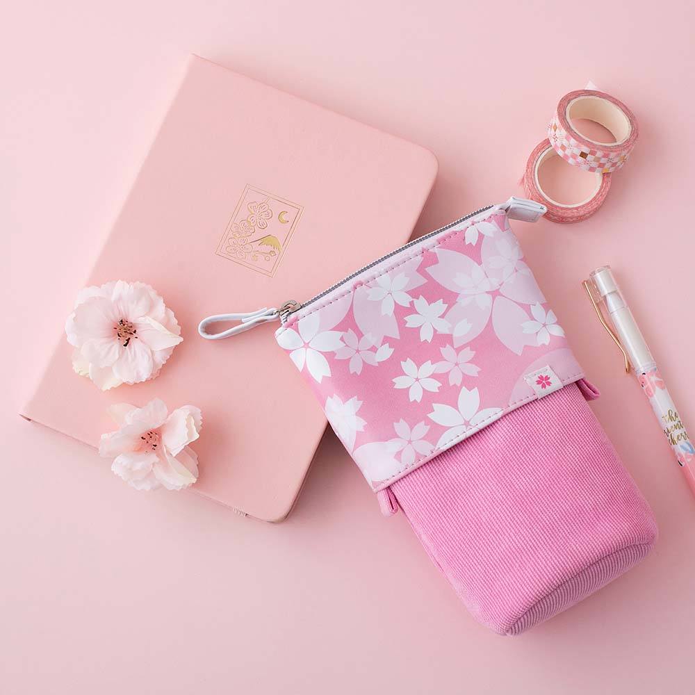 Tsuki 'Sakura Edition' Pop-Up Pencil Case in petal pink with sakura blooms and Tsuki 'Sakura Edition' Washi Tapes on Tsuki 'Sakura' Limited Edition Bullet Journal in petal pink with white pen on light pink background