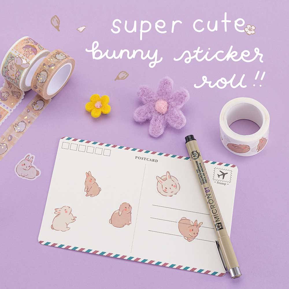 Super cute bunny sticker roll from Tsuki Bunny Blush Washi Tape Set designed with Blossom Bujo on postcard with pen and felt flowers on lilac background