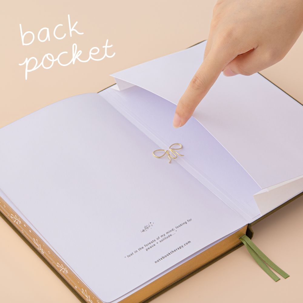 Hand opening the expandable back pocket of the tsuki mori bullet journal